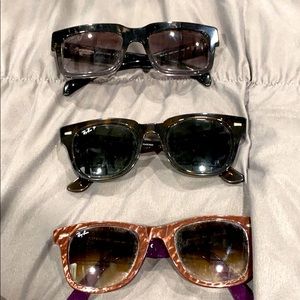 3 pairs of sunglasses: 2 ray ban and one Prada